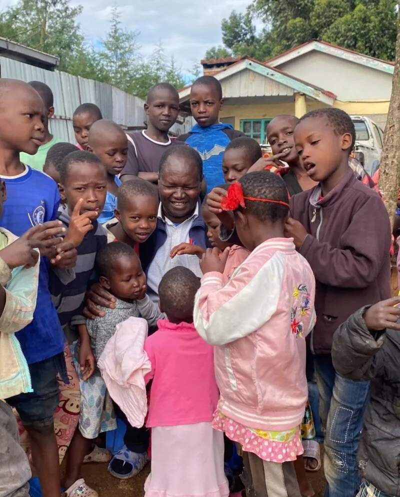 Joseph standing with a group of children at the home